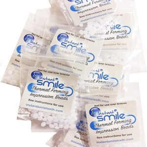 A pack of 12 Packages of Instant Smile Billy Bob Replacement Thermal Adhesive Fitting Beads for Fake Teeth in a plastic bag.