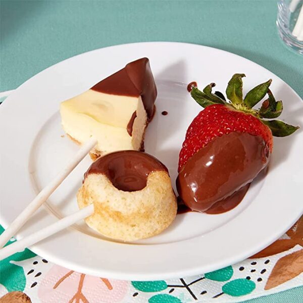 A plate with ChocoMaker Milk Chocolate Microwavable Fondue and Fountain Dipping Candy - 2 Pound Bag covered strawberries, cheesecake, and chocolate dipped strawberries.