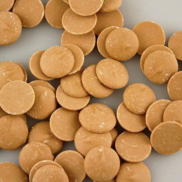 A pile of Make N Mold 6212 12OZ Salted Caramel Flavored Candy Wafers on a white surface.